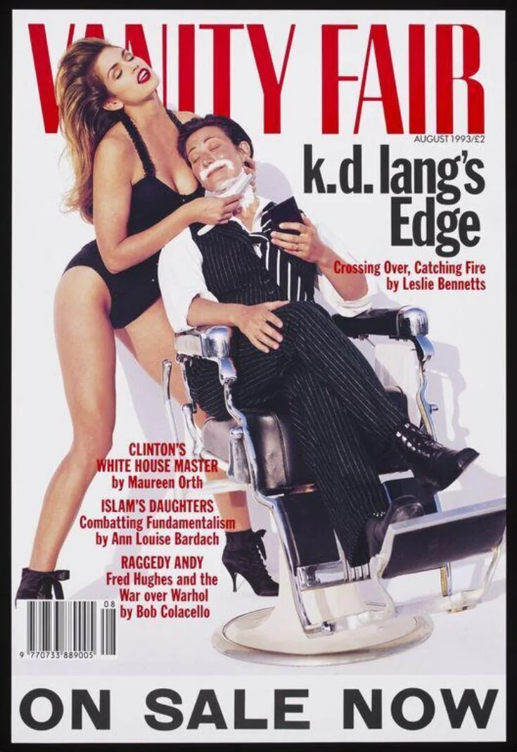 Cindy Crawford in a black corset and briefs shaving singer k.d. lang in a barber chair, photographed by Herb Ritts for Vanity Fair in 1993
