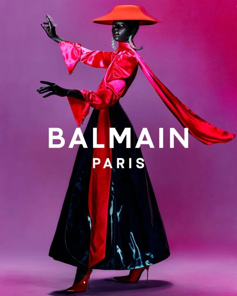 Model in red and black Balmain styling against a vivid magenta background, photographed by Rafael Pavarotti