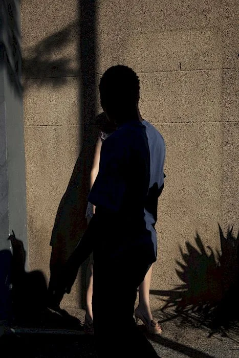 Figure in deep shadow beside a sunlit textured wall in Mirte by Viviane Sassen, 2011