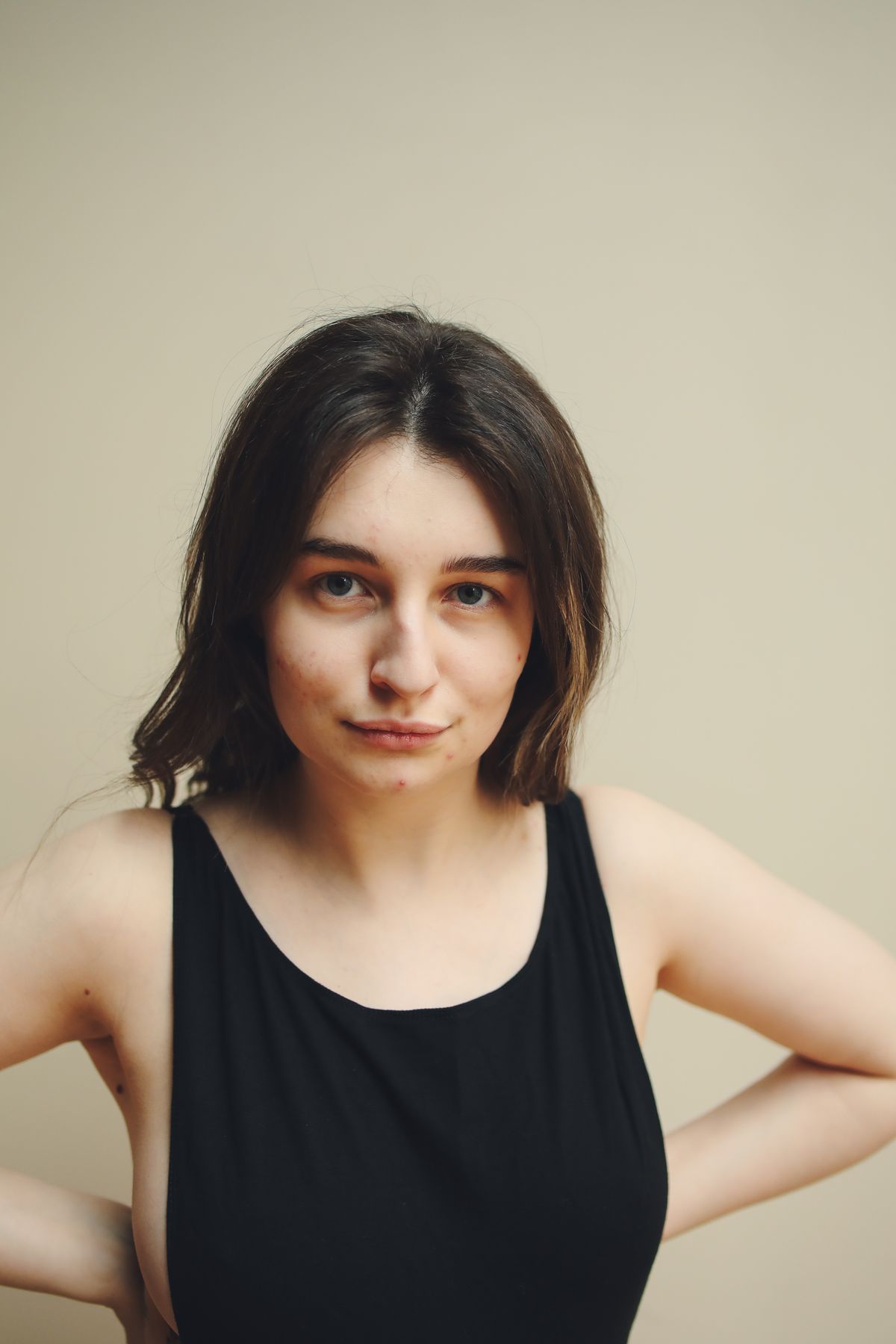 Beispielportrait einer Frau im schwarzen Top vor hellem Hintergrund